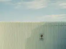 A pale corrugated gate with a no-parking sign in Napoli.