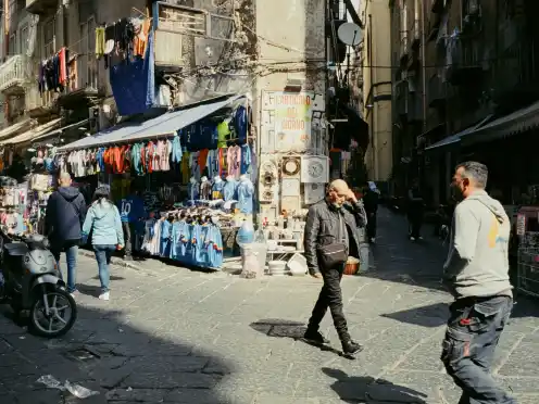 A busy street market selling football shirts and souvenirs in Napoli.