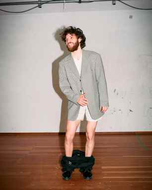 Portrait of Marlon Bienert laughing with his pants down on stage
