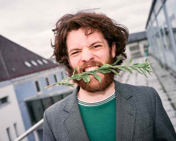 Portrait of Marlon Bienert with flowers in his mouth