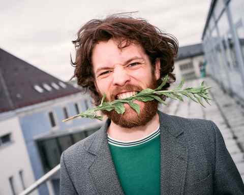 Portrait of Marlon Bienert with flowers in his mouth