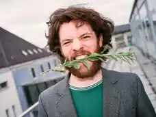 Portrait of Marlon Bienert with flowers in his mouth
