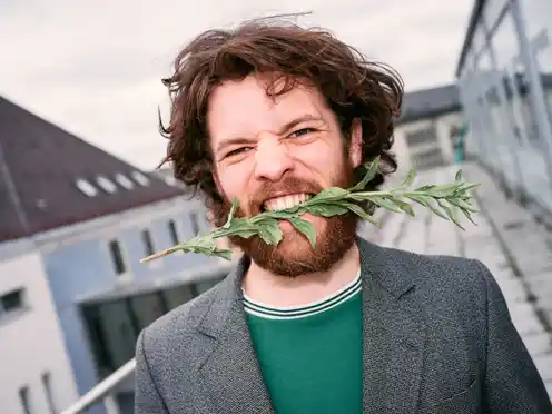 Portrait of Marlon Bienert with flowers in his mouth