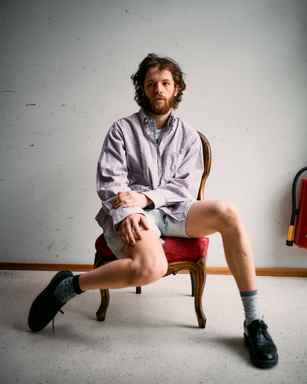 Portrait of Marlon Bienert in shorts sitting in a chair