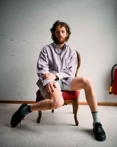 Portrait of Marlon Bienert in shorts sitting in a chair
