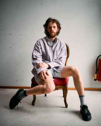 Portrait of Marlon Bienert in shorts sitting in a chair