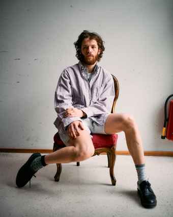 Portrait of Marlon Bienert in shorts sitting in a chair