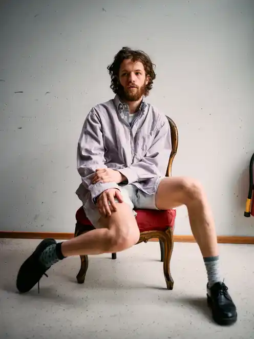Portrait of Marlon Bienert in shorts sitting in a chair