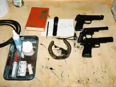 Backstage prop table with toy pistols, makeup supplies, and a book at The Master and Margarita