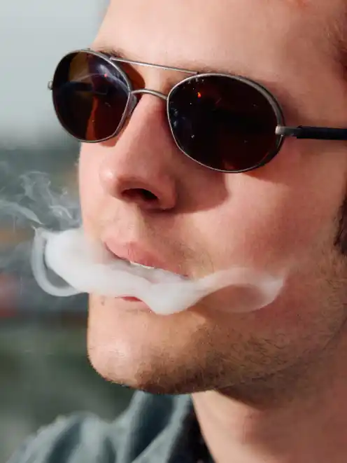 A close-up portrait of man smoking from the project Elsewhere