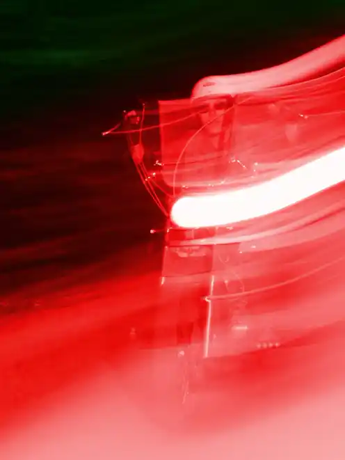 A blurred motorbike rider from the front shot with a red flash from the project Elsewhere