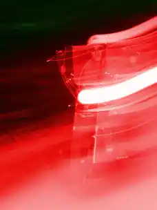 A blurred motorbike rider from the front shot with a red flash from the project Elsewhere